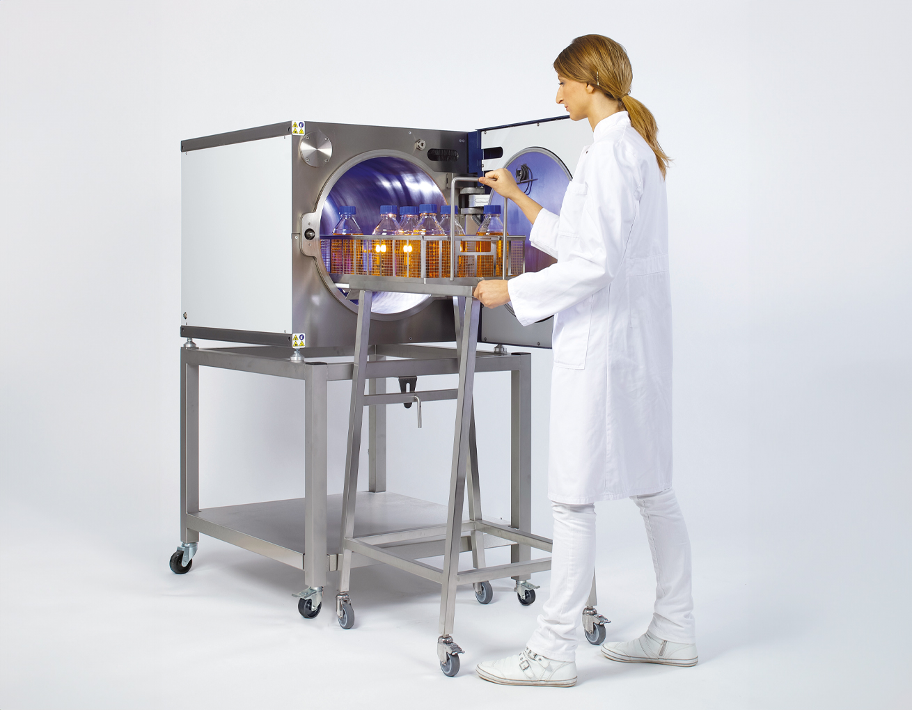 Woman operating a sterilization machine.